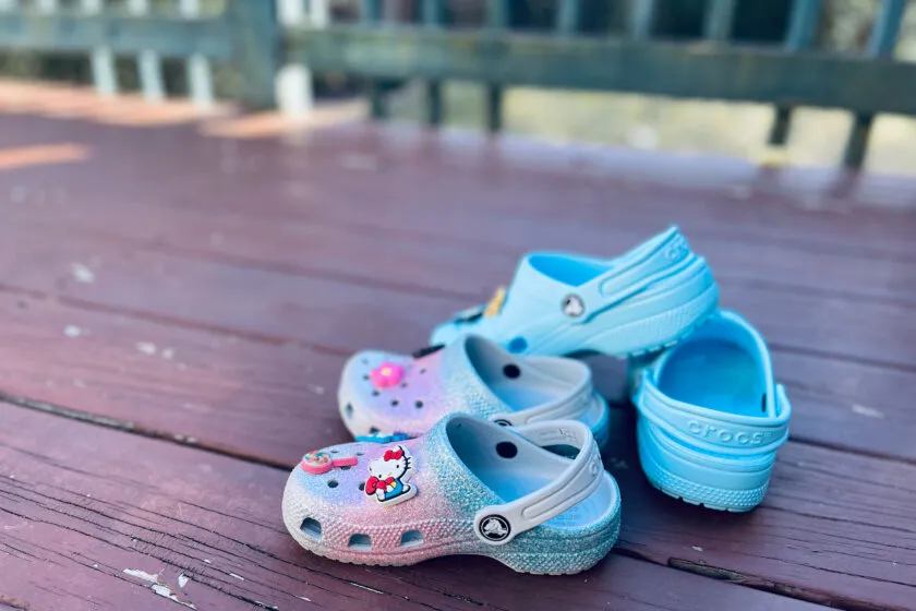 blue and pink Crocs shoes in pile on deck.