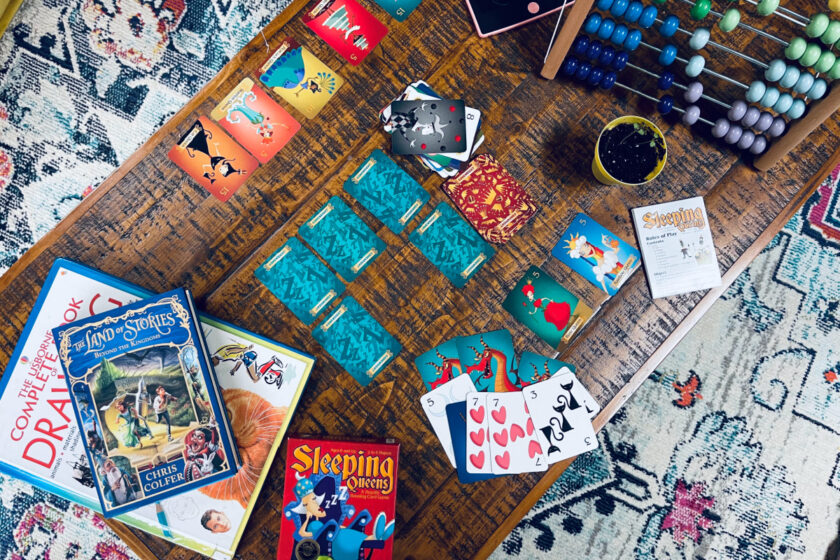 Sleeping Queens card game, abacus, plant and books on coffee table in homeschool family home.