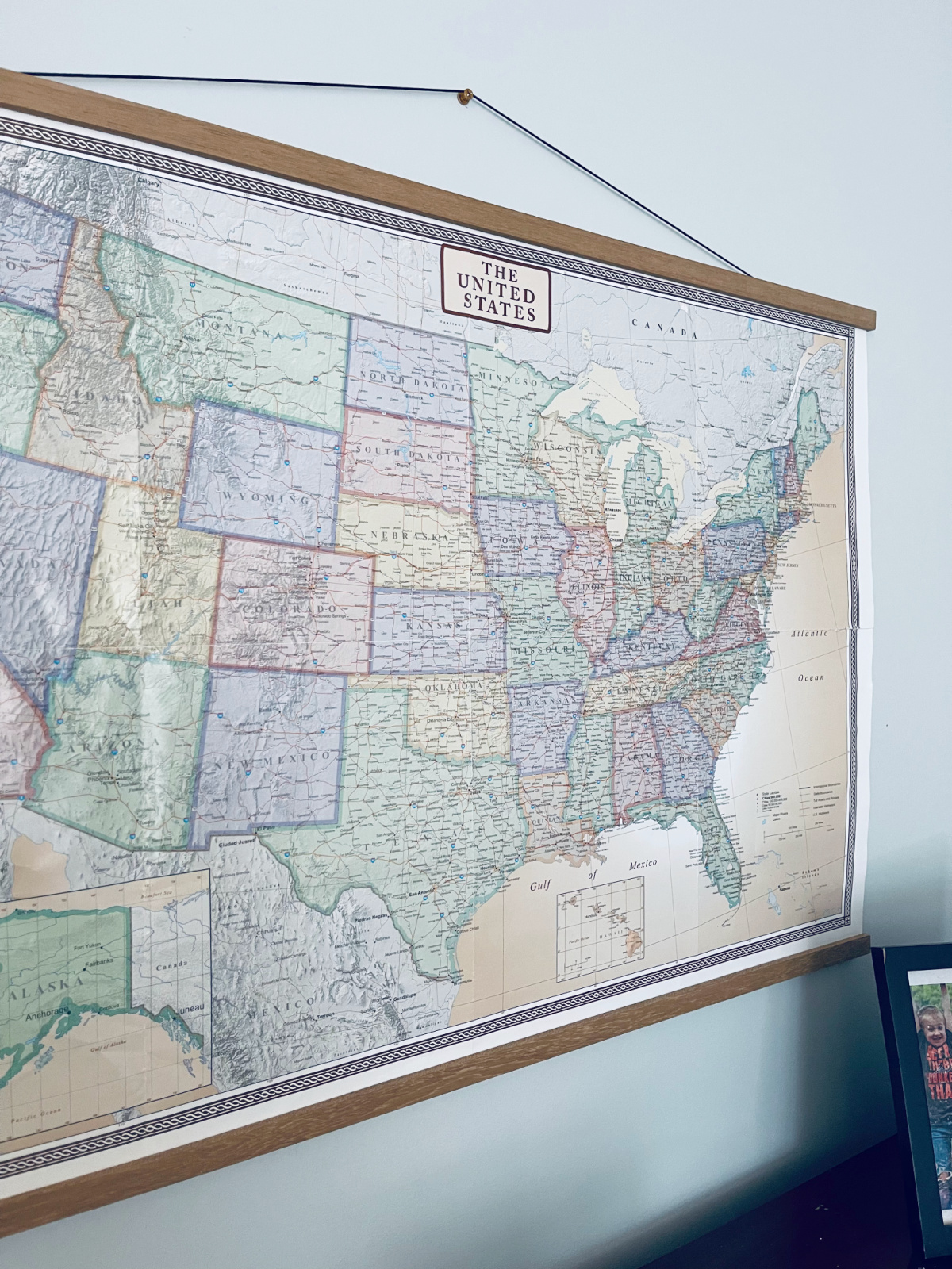 United States wall map with poster hanger on wall.