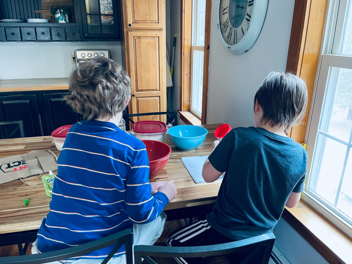 two brothers doing baking experiments together at the kitchen table.