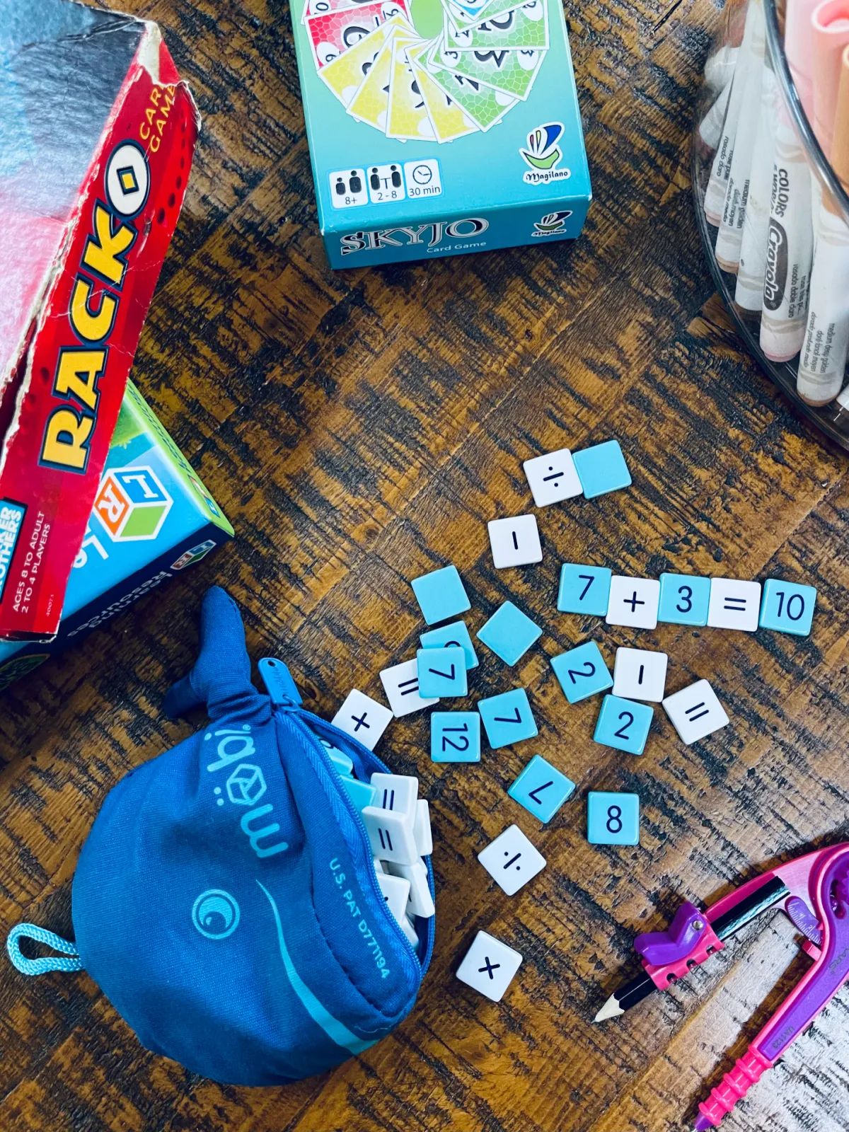 math tiles set up in equations on coffee table with compass and math games nearby.