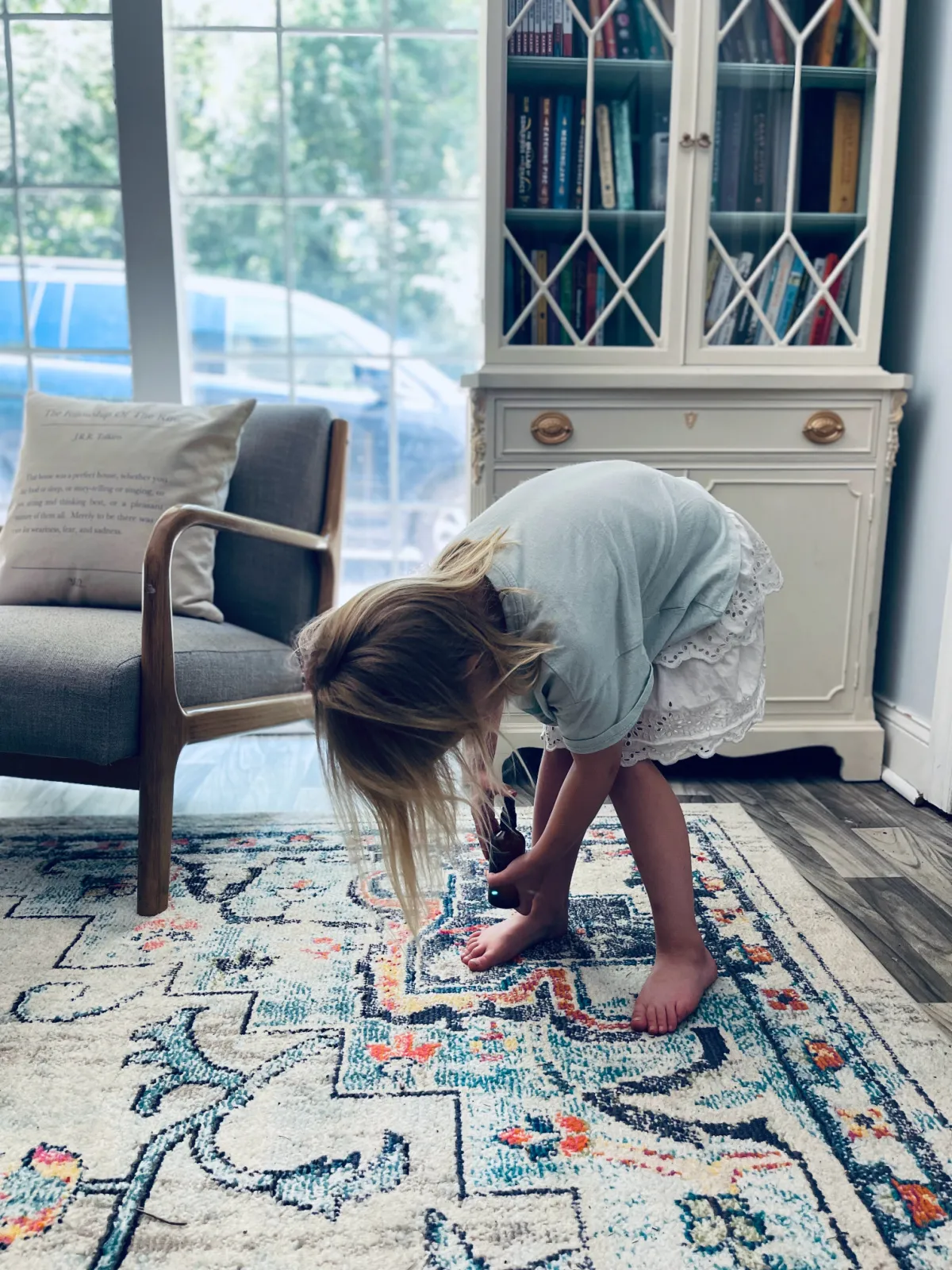 young child putting on bug spray.