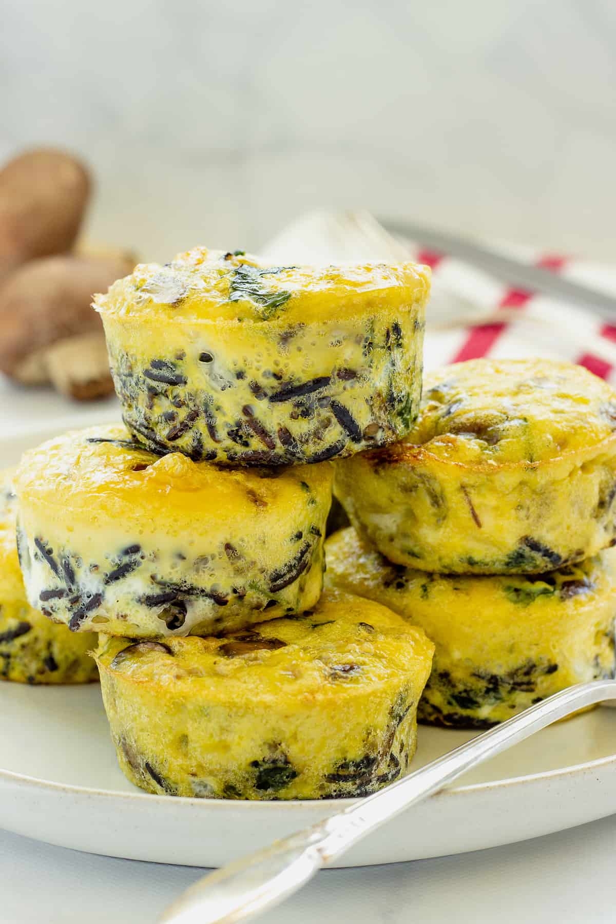 healthy egg muffin cups stacked on plate with fork.