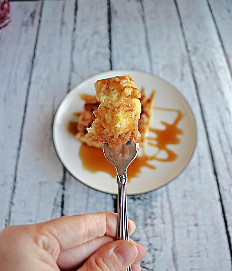 fork holding a bite of overnight french toast casserole.