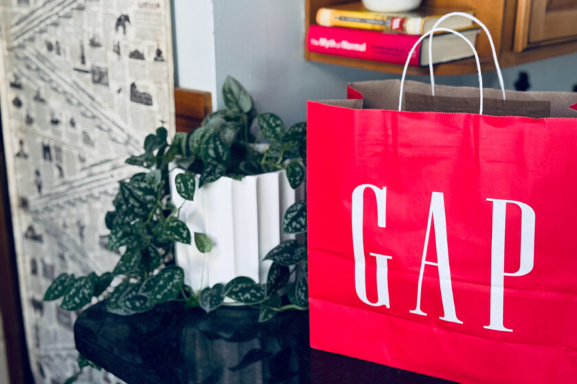 red GAP shopping bag on counter next to plant.