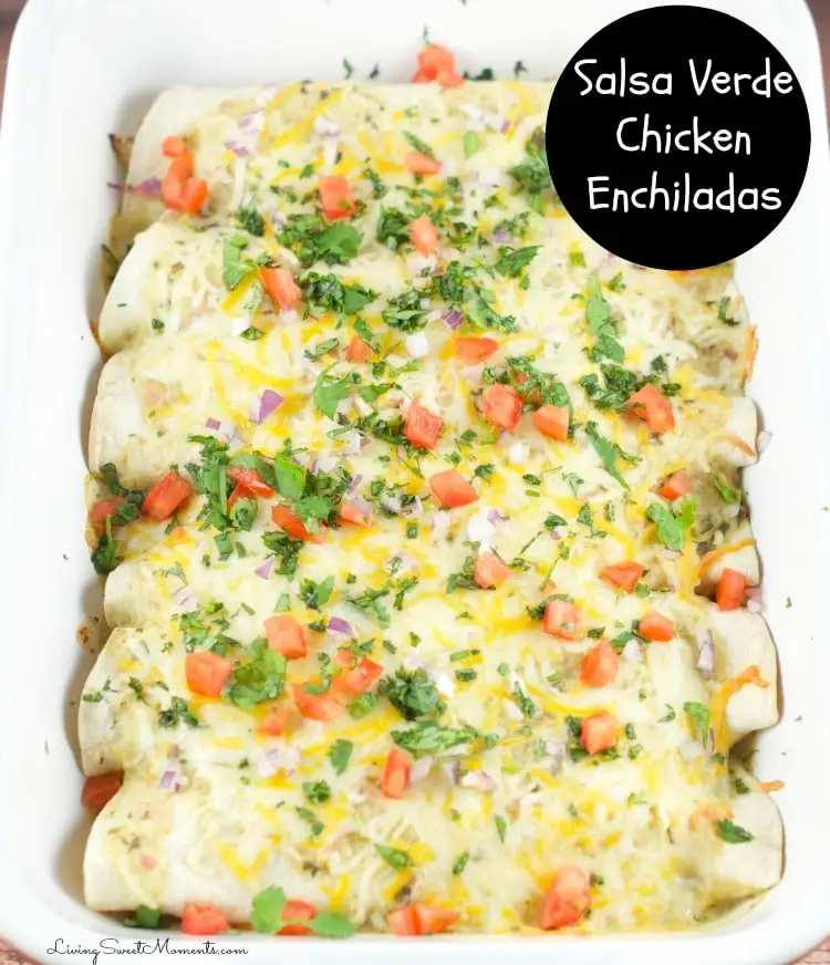 salsa verde chicken enchiladas in casserole dish sprinkled with cilantro, red onions and tomatoes.