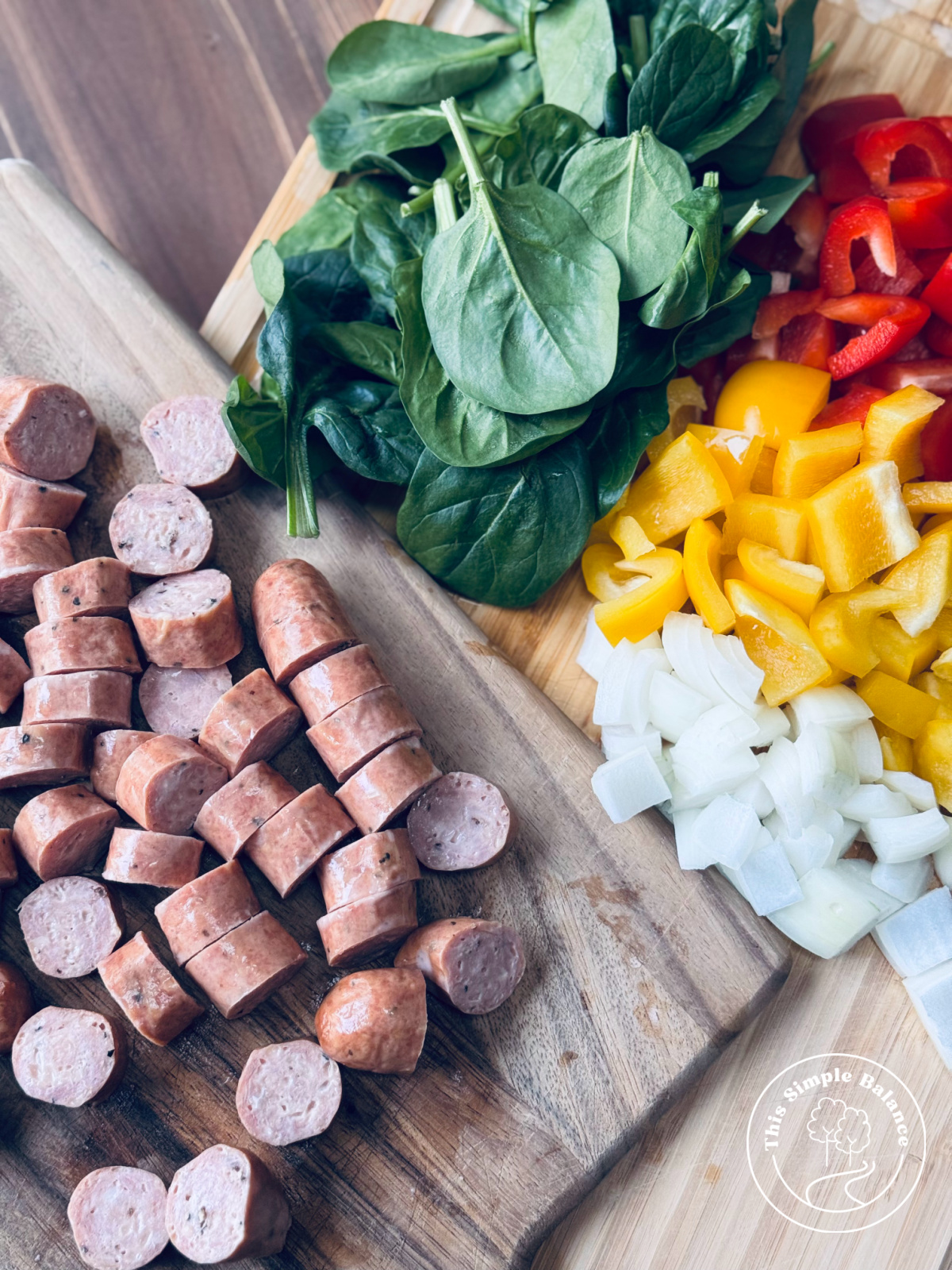 chopped ingredients for chicken sausage stir fry on two separate, but overlapping cutting boards.