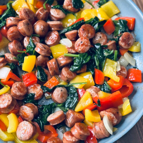 colorful chicken sausage stir fry with red and yellow bell peppers, spinach and onions.