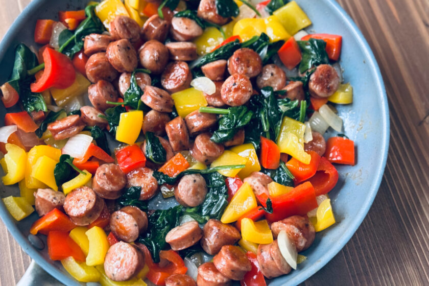 colorful chicken sausage stir fry with red and yellow bell peppers, spinach and onions.