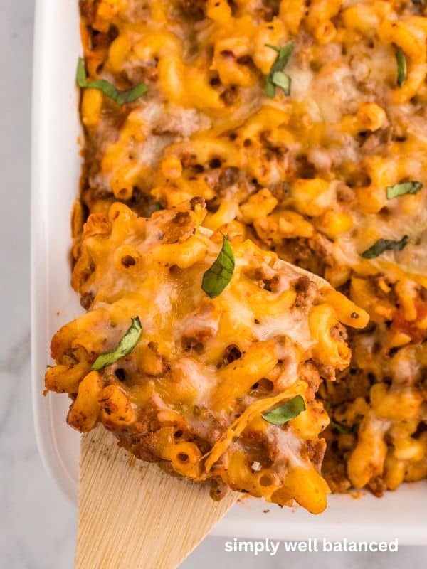 Cheesy ground beef zuchinni casserole in white casserole dish.