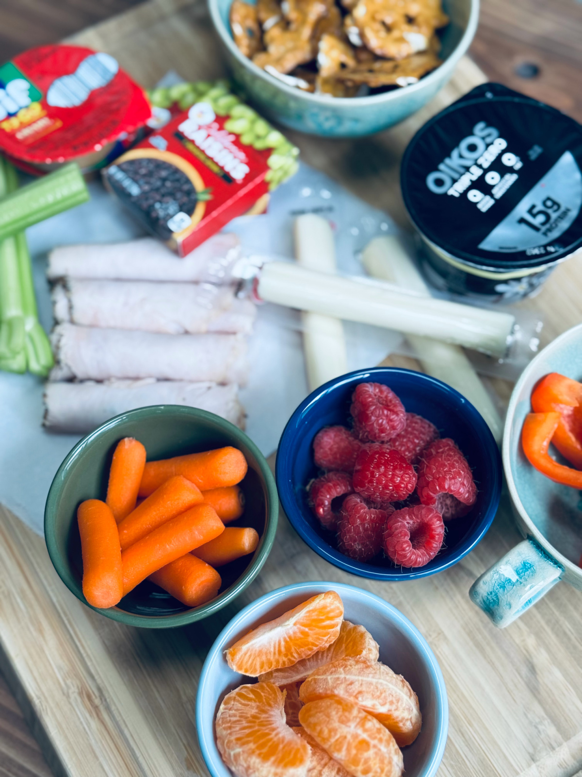 snack platter for kids with mandarin oranges, baby carrots and raspberries in focus.