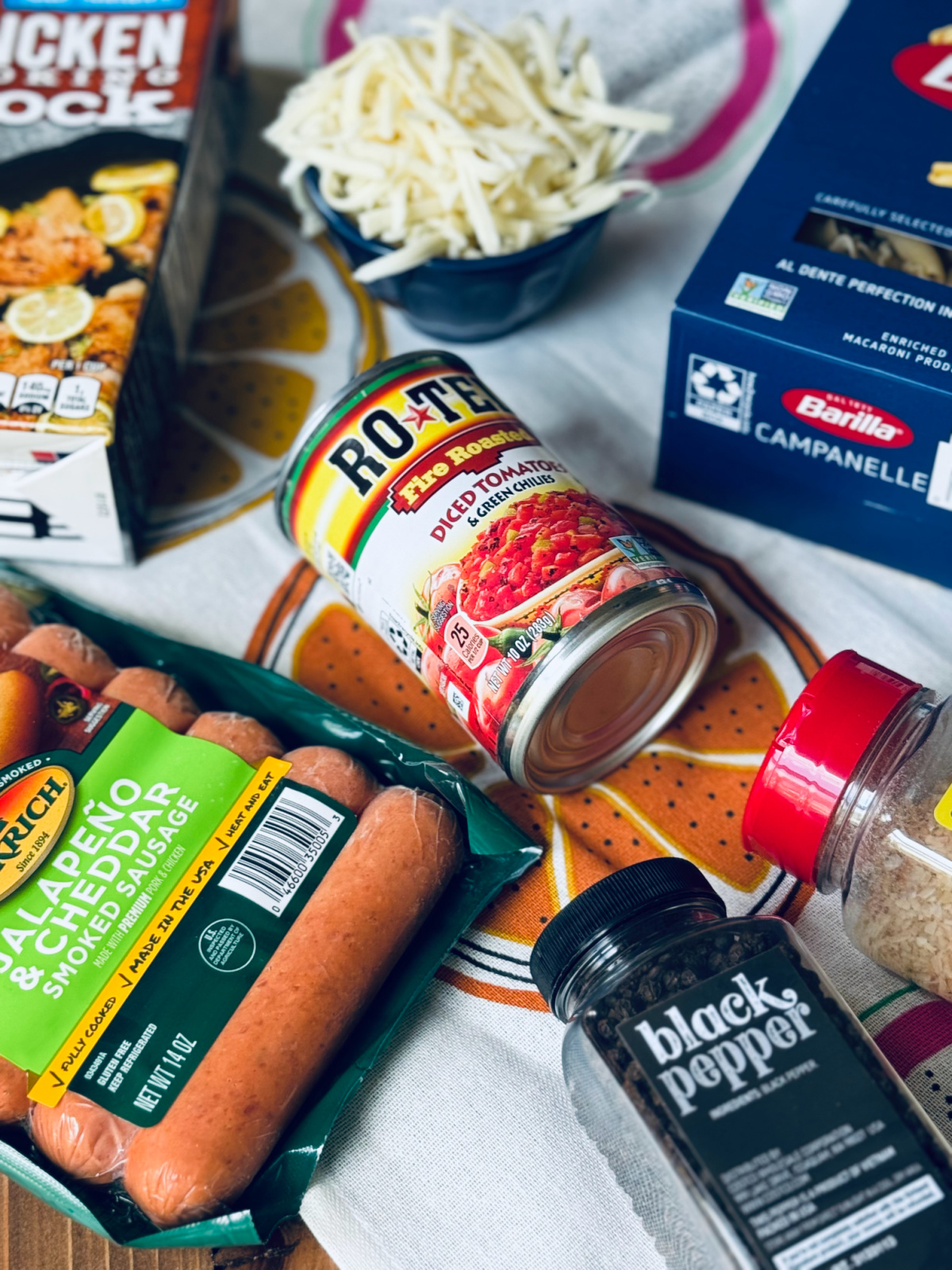 ingredients for easy jalapeno sausage skillet spread out decoratively on colorful tea towel.