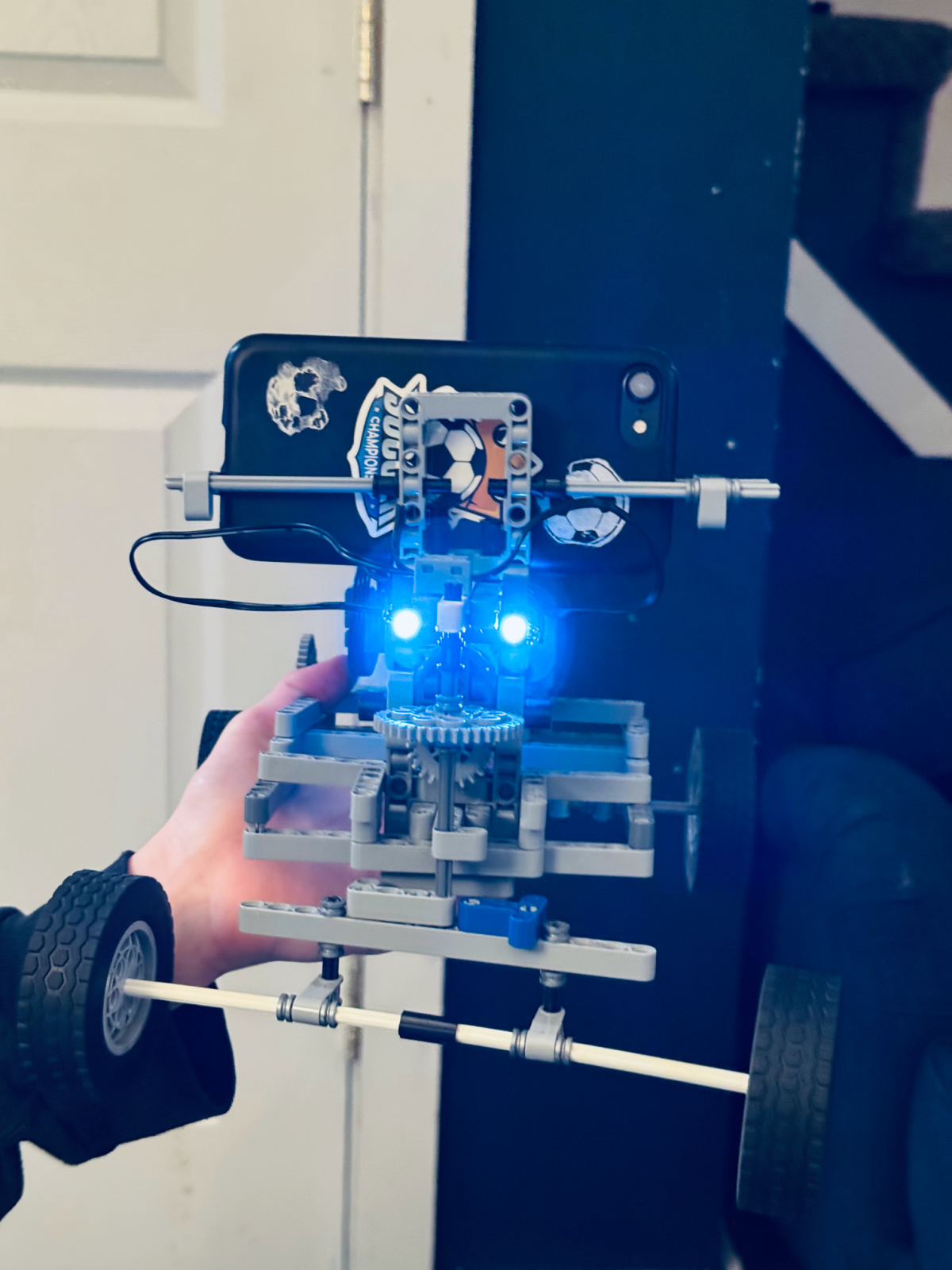 LEGO technic robot build holding iphone.