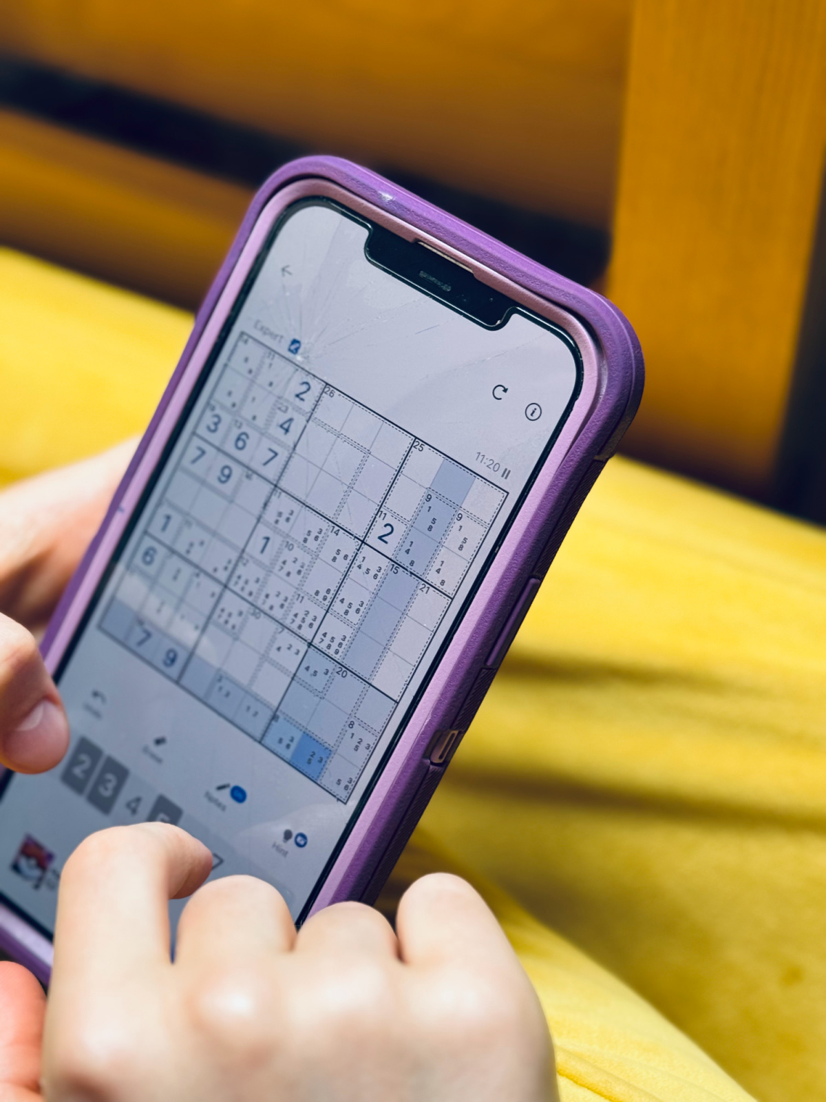 unschooled kid doing a difficult Sudoku puzzle on her phone.