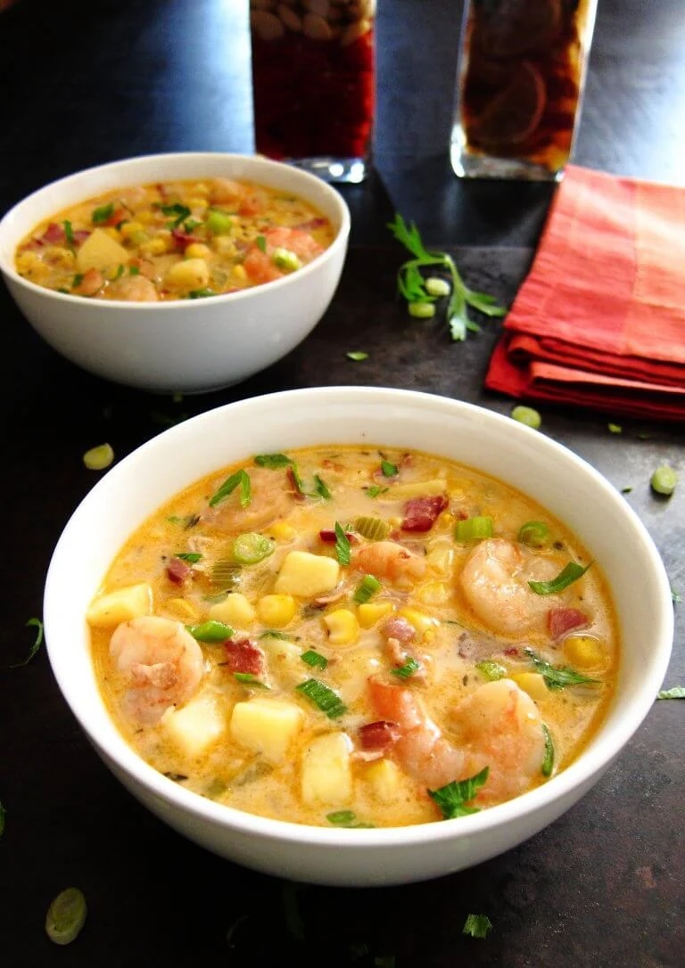creamy chipotle shrimp soup in white bowl topped with chopped green onions.