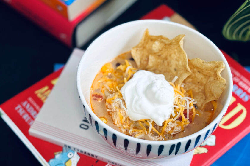 bowl of chicken tortilla soup with chips, shredded cheese and source cream.