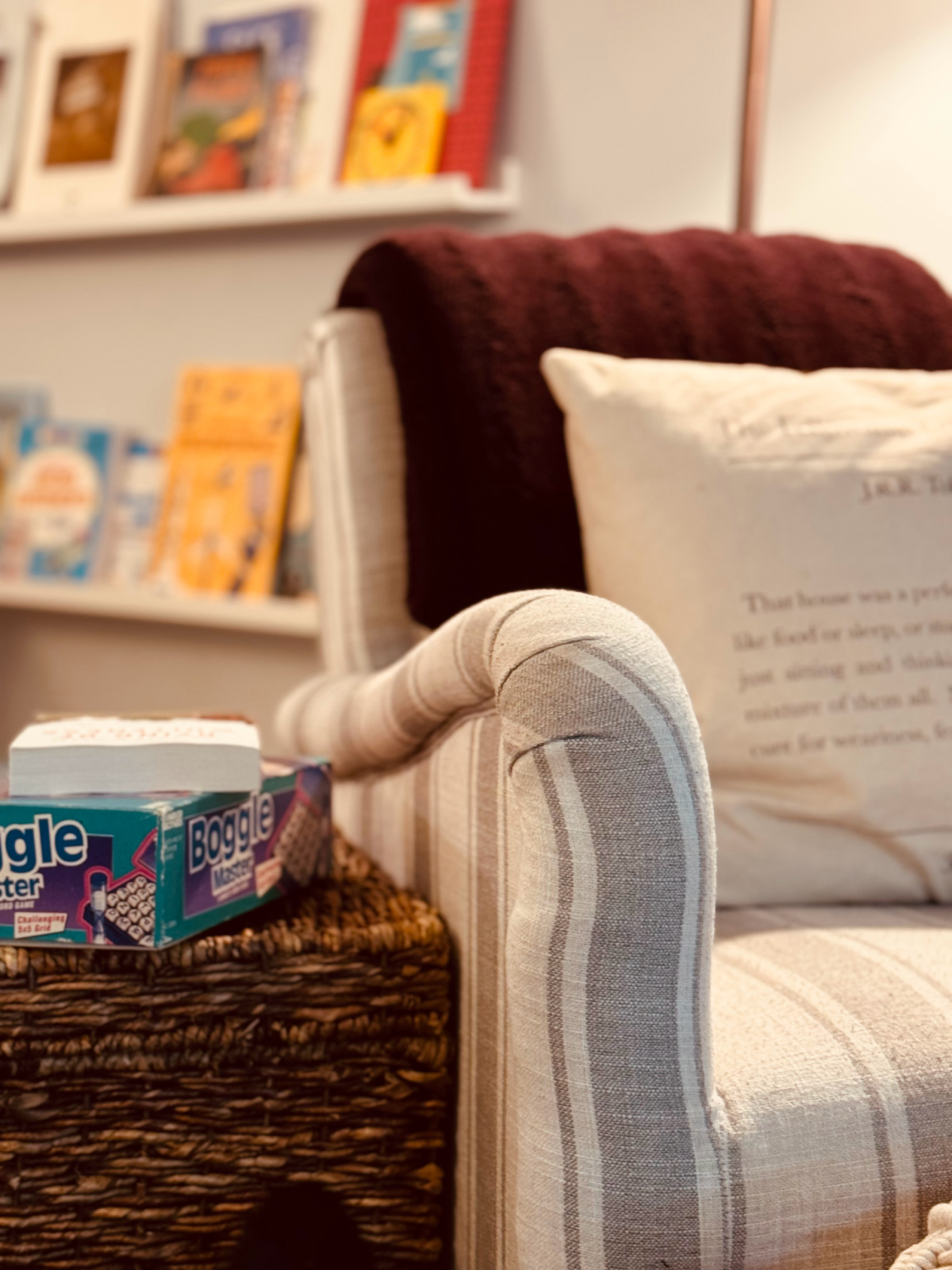 thrifted gray and white striped chair with arm in focus, living frugally in order to homeschool concept.