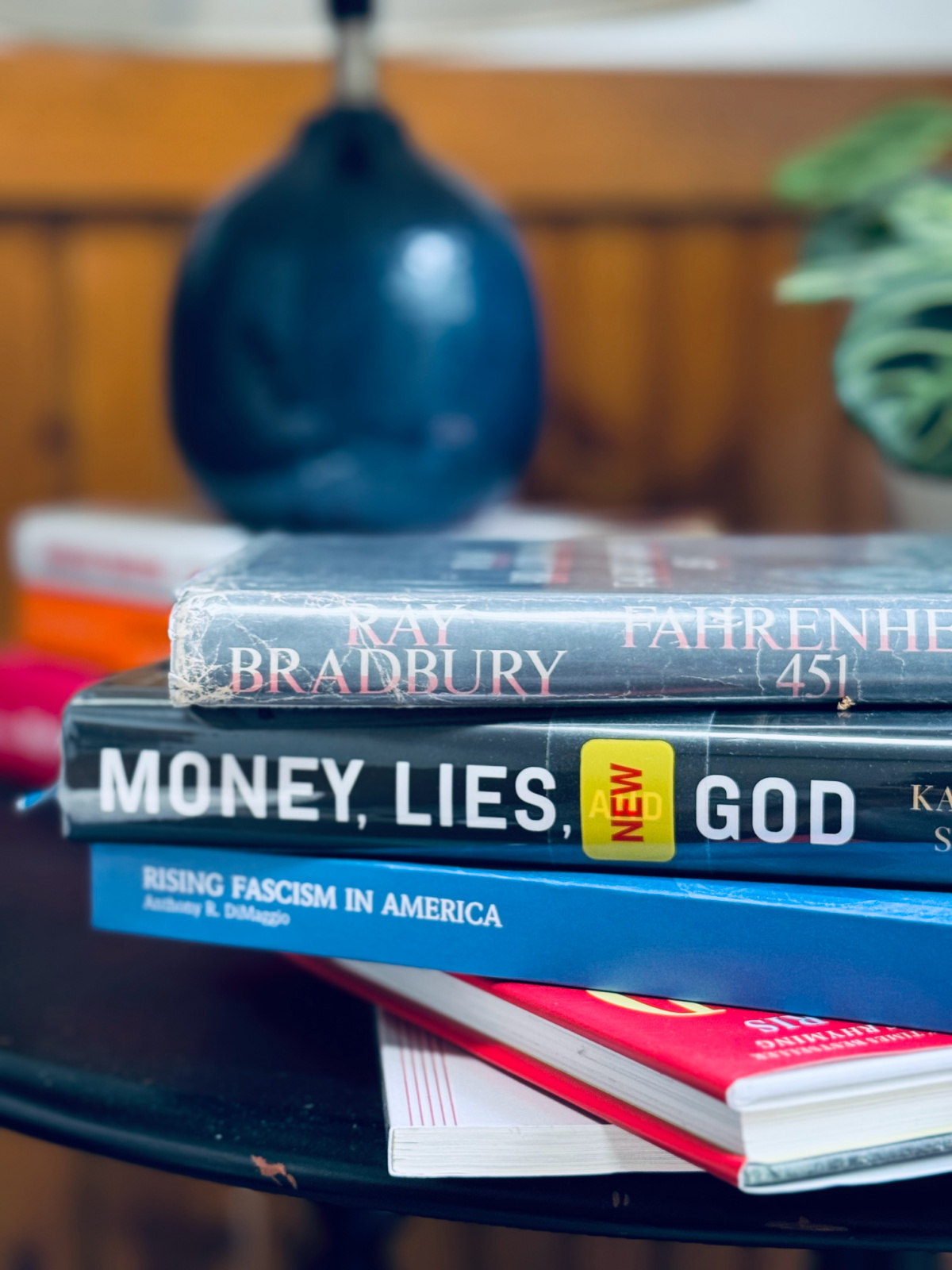 Books Farenheit 451, Money Lies and God, Rising Fascism in America in stack on table.