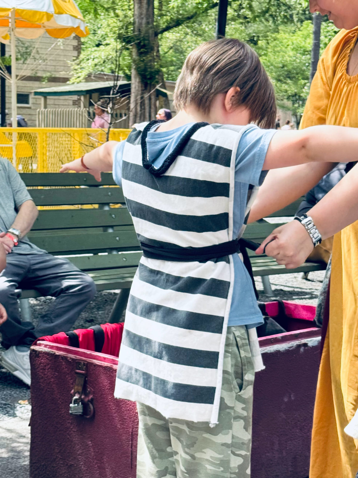 child being dressed up for a play at local amusement park.