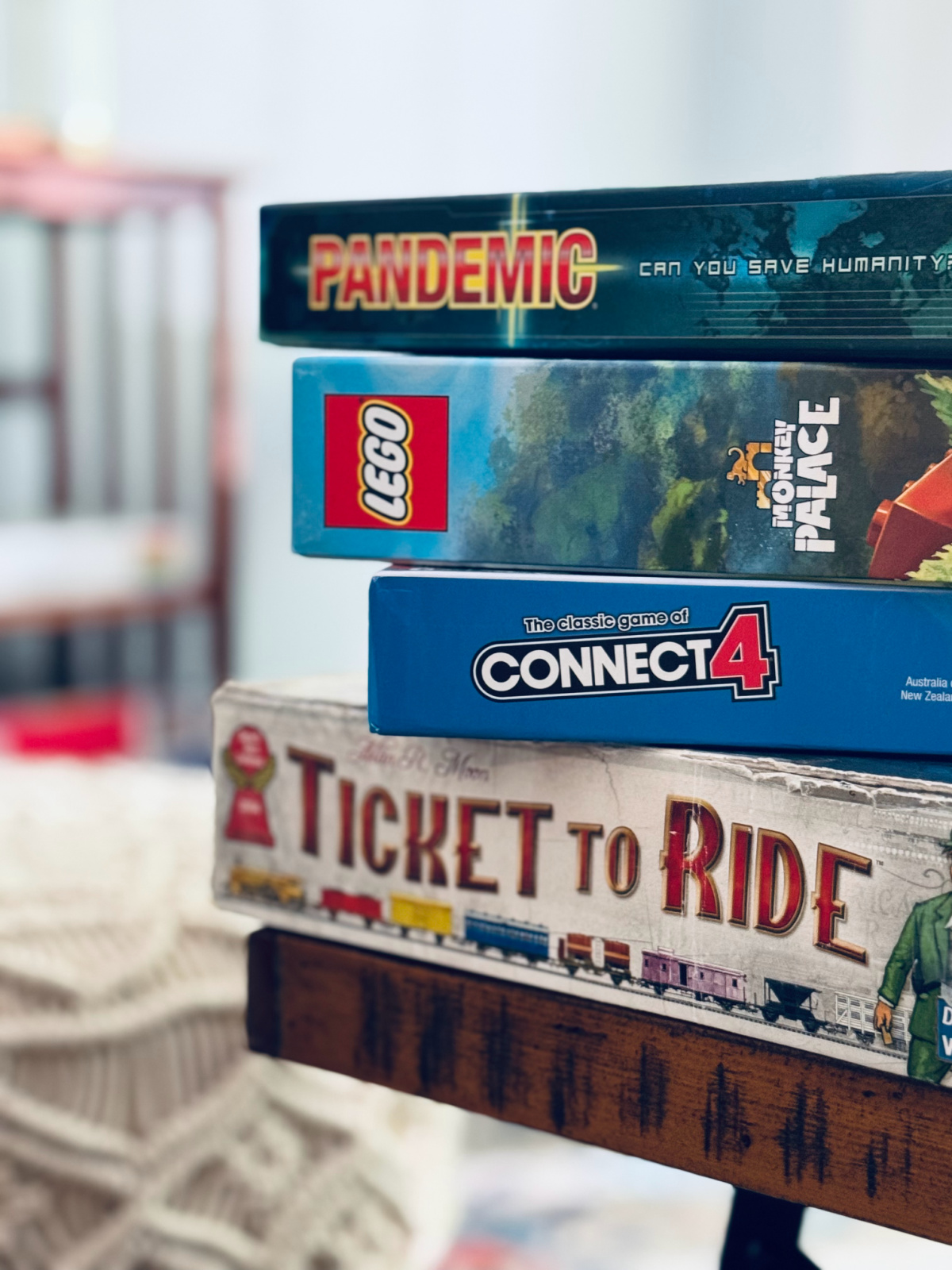 stack of board games on coffee table with games in focus.