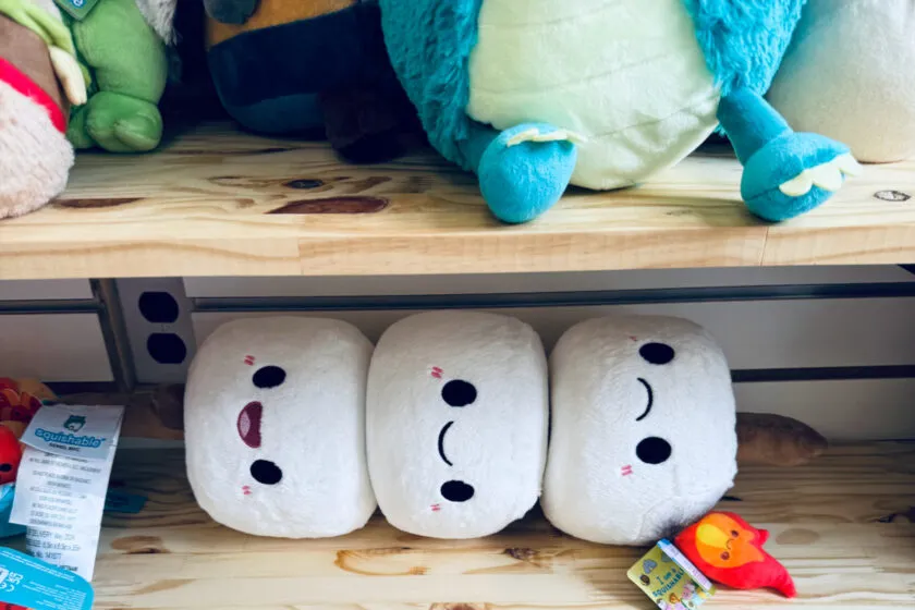 stuffed animal marshmallows on shelf below other stuffed animals.