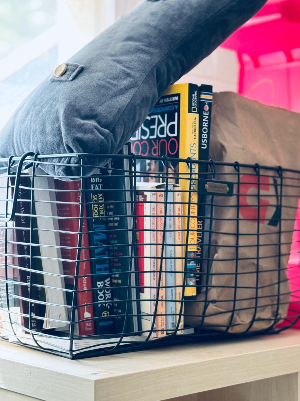 a black metal basket with decluttered items that need to leave the house.