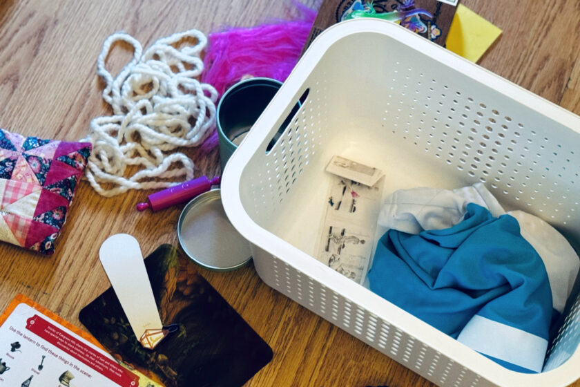 white bin with maximalist child's treasures, with some strewn around on the floor.
