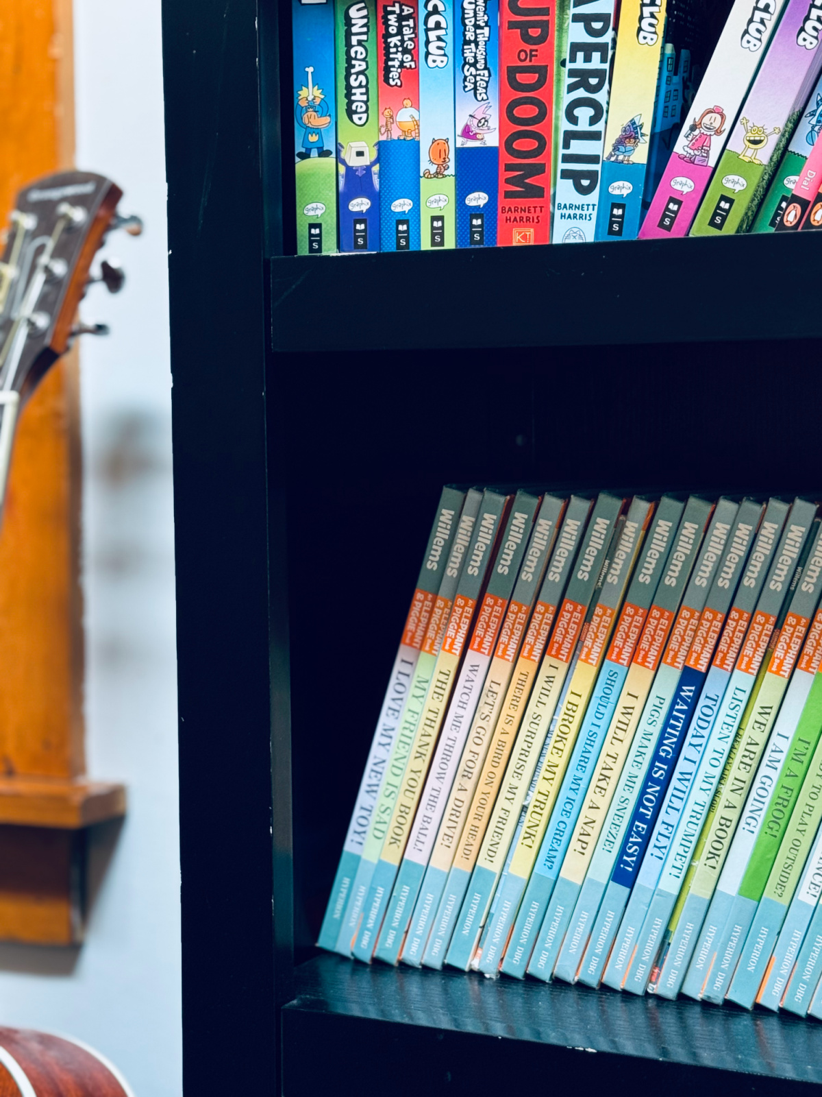 Mo Willems books on black bookshelf.