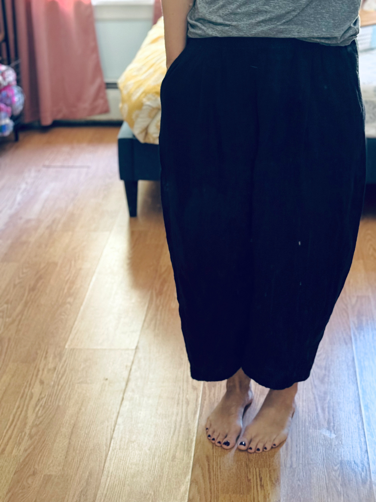 Black gauze barrel pants in focus.