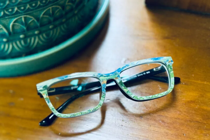Pairs glasses with Van Gogh toppers on shelf.