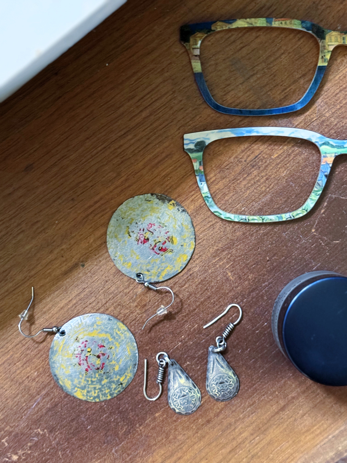 Pairs glasses toppers and earrings in drawer with lip gloss.