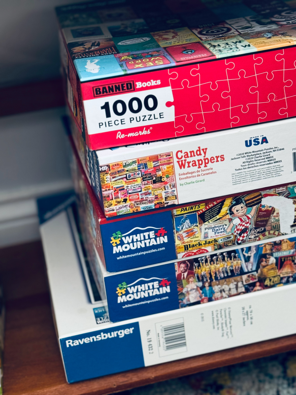 Stack of puzzles on shelf.