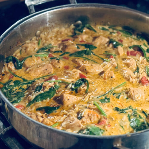 Finished creamy roasted red pepper and chicken orzo in skillet on stovetop