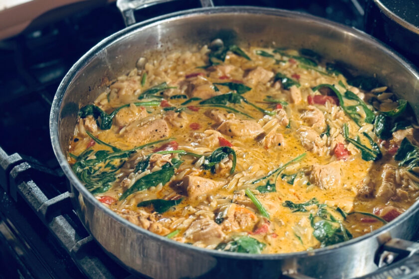Finished creamy roasted red pepper and chicken orzo in skillet on stovetop