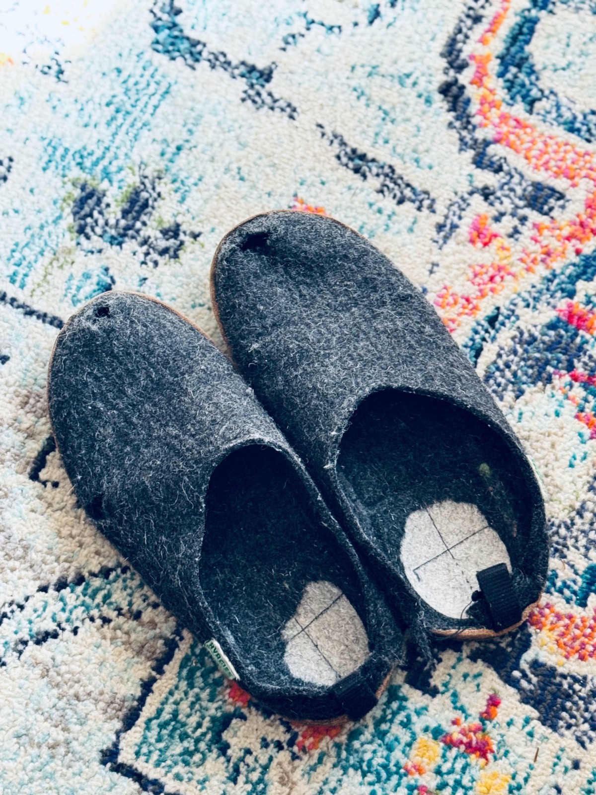 worn out pair of Kyrgies slippers with holes and worn out soles.