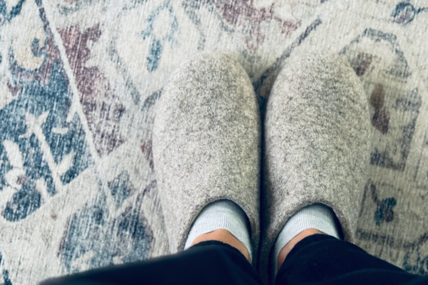 Kyrgies classic slippers in focus on vintage rug.