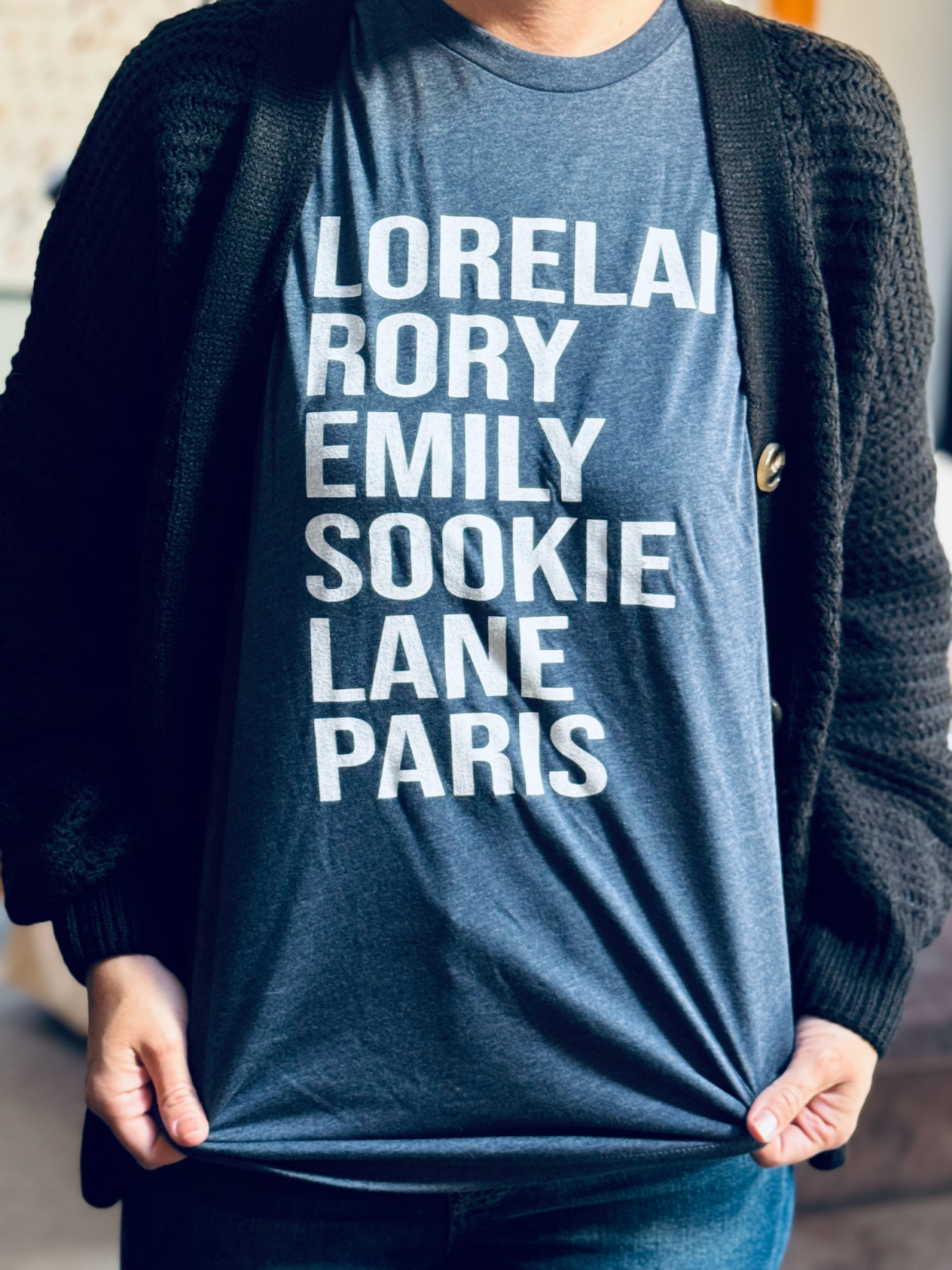 navy Gilmore Girls t-shirt with text in focus that says "Lorelai Rory Emily Sookie Lane Paris".
