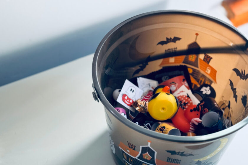 Halloween candy alternatives in bucket mixed with Halloween candy.