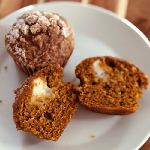 pumpkin cream cheese muffin cut open to show filling.