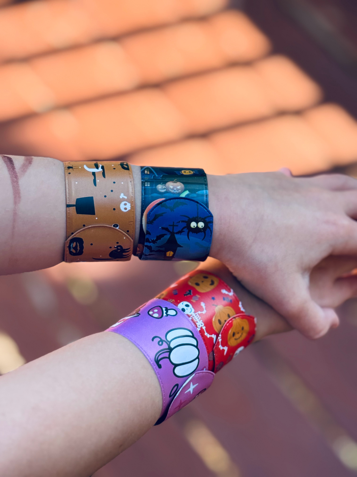 Halloween slap bracelets on child's arms.