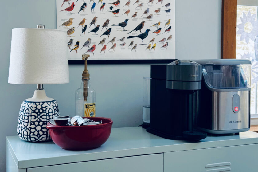 nespresso machine and ice machine on metal cabinet with lamp and red bowl.