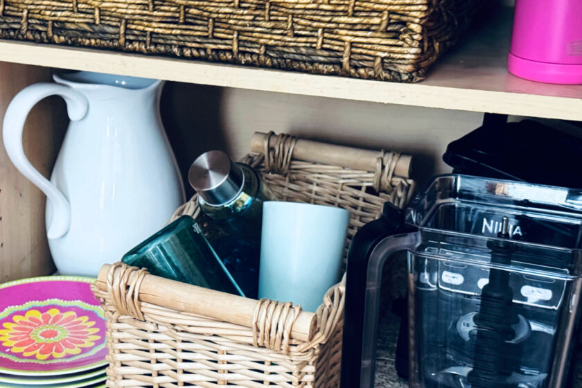 kitchen cabinet with baskets for organizing cups.