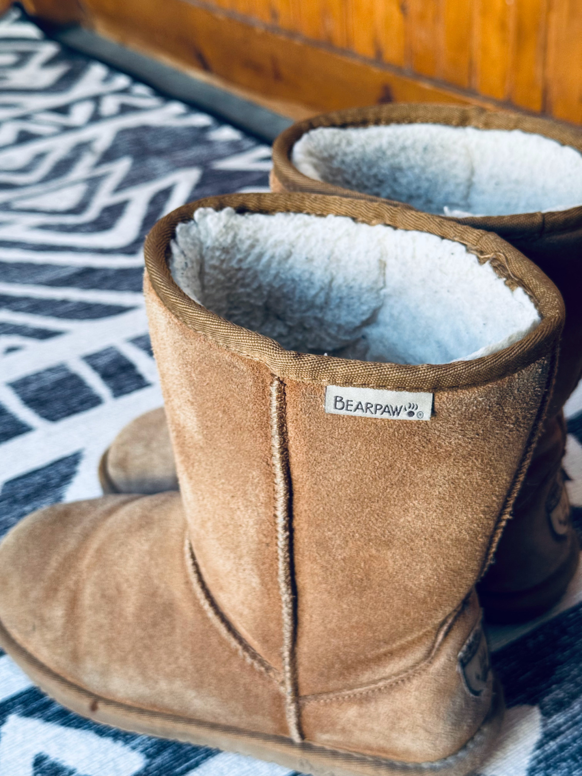 Bear Paw mid rise boots with logo tag in focus.