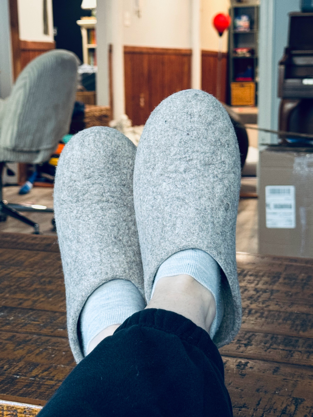 krygies slippers on feet propped up on coffee table.
