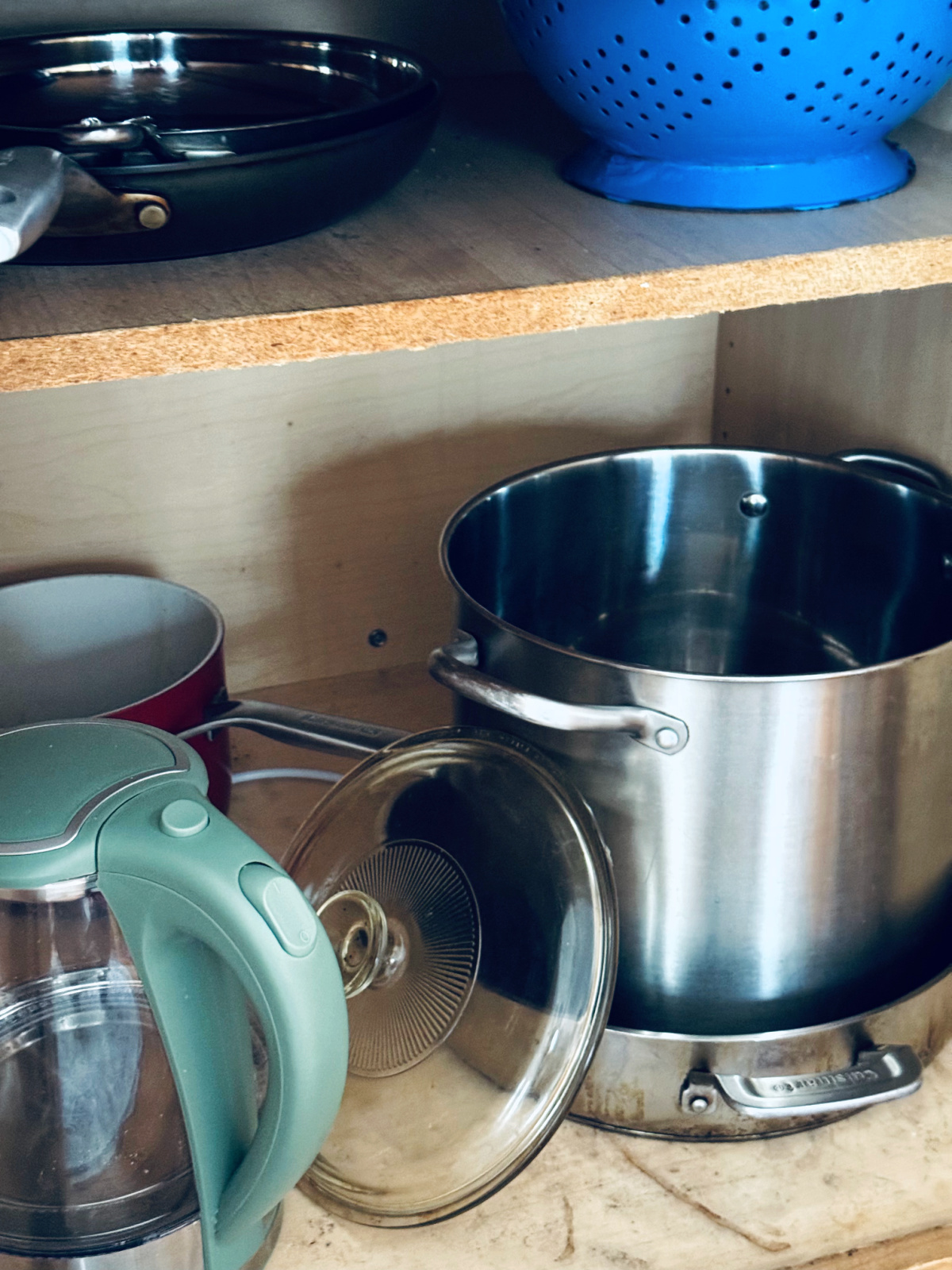 pots and pans in cabinet, with lid to be decluttered.