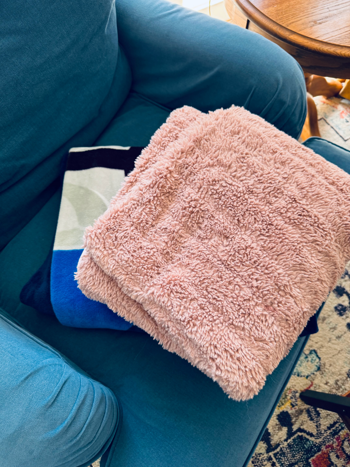 old throw blankets folded, sitting on chair waiting to be decluttered.