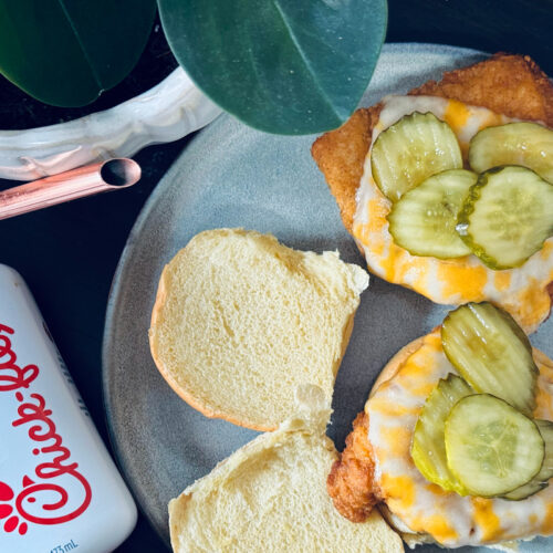 copycat chick fil a chicken sandwiches, open face on plate with chick fil a sauce and plant nearby