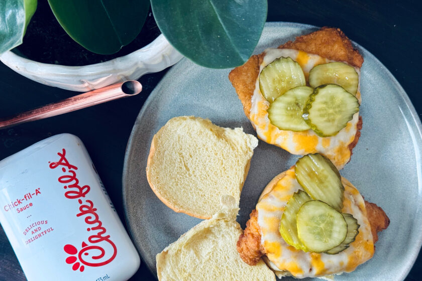 copycat chick fil a chicken sandwiches, open face on plate with chick fil a sauce and plant nearby