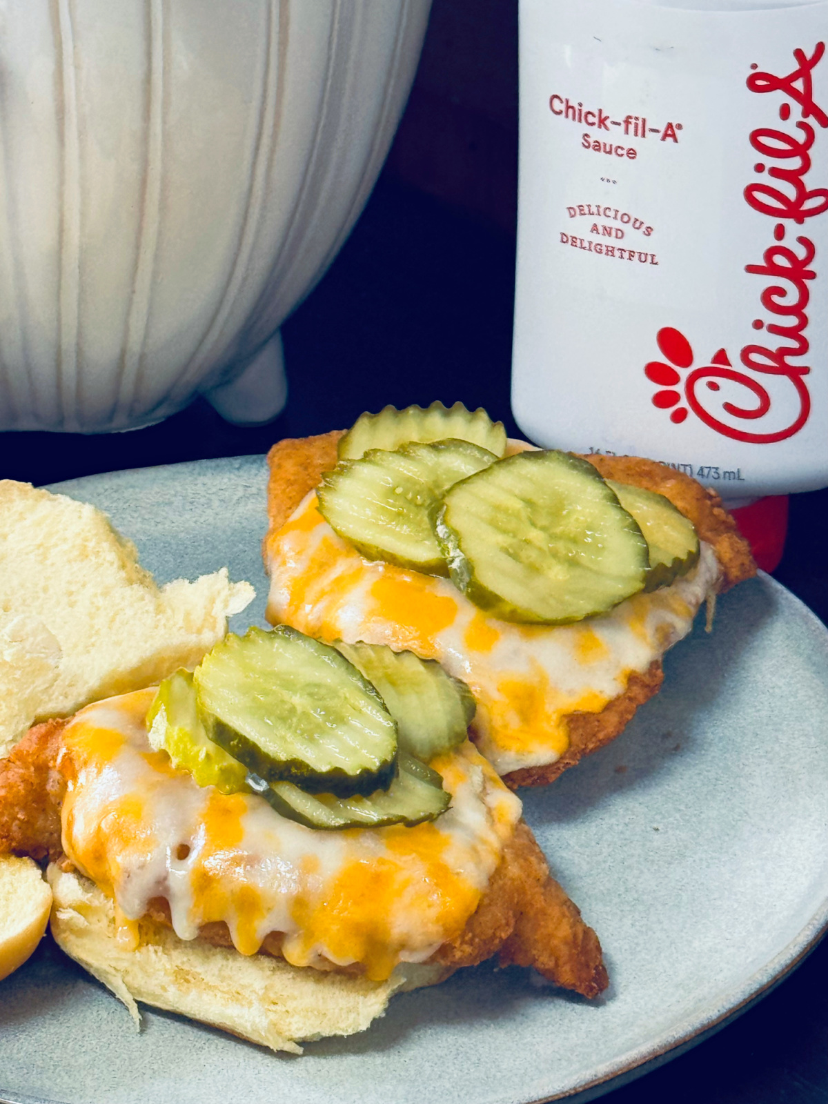 copycat Chick-Fil-A chicken sandwiches open face on place with Chick-Fil-A sauce in background.
