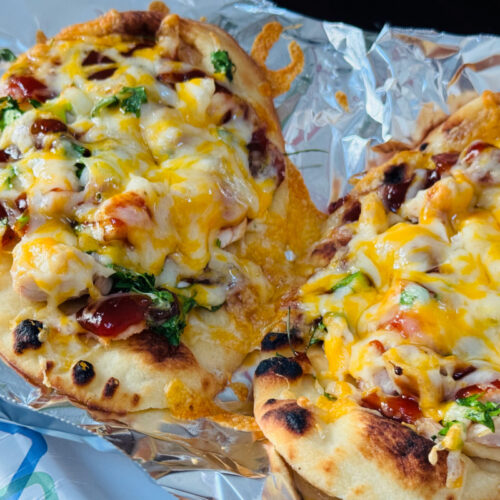 Mini BBQ chicken naan pizzas on tin foil.